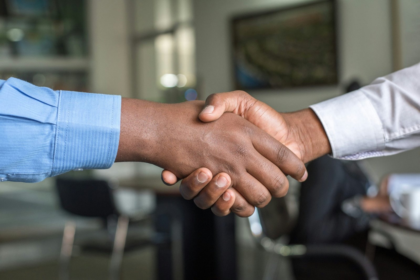 two men shaking hands with one holding a handshakt